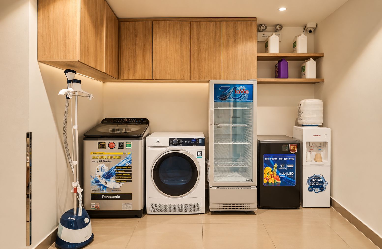A laundry room with a washing machine, a dryer, a vacuum cleaner, and a refrigerator.
