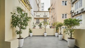 A narrow balcony with potted plants and a tiled floor. - Mihn Suites Ben Thanh (Ho Chi Minh City)
