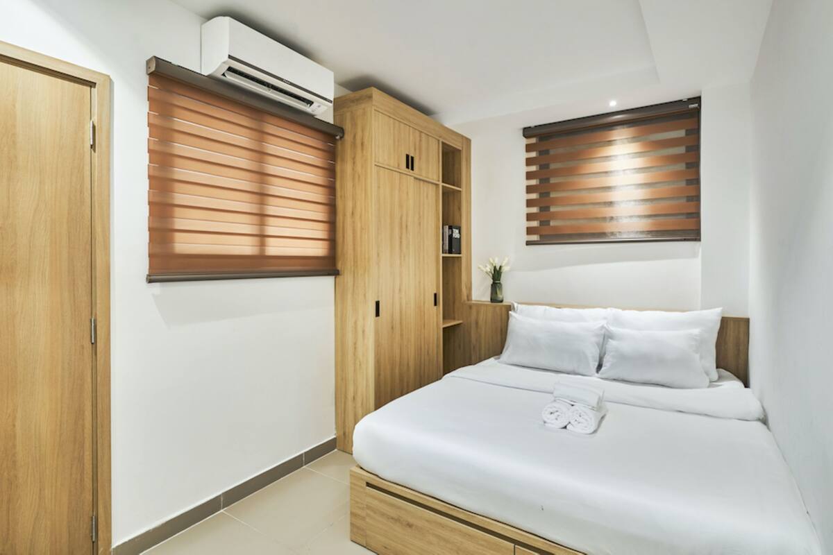 Une chambre à coucher avec un lit, une armoire en bois et des étagères intégrées.