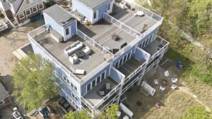 A multi-story building with a deck, outdoor seating, and a small garden area. - Lakefront Condo, Only Steps To The Beach (Michigan City)