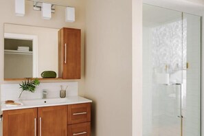 Relax in a serene bathroom with a vanity, shower enclosure, and potted plant.