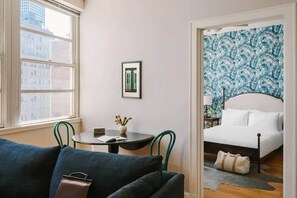 Experience the city from your retreat, featuring a large window, a comfortable bed, and a stylish seating area.