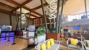 A lobby with a reception desk, seating area, and a large screen displaying information.