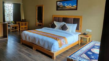 A bedroom with a wooden bed, a desk, and a chair.
