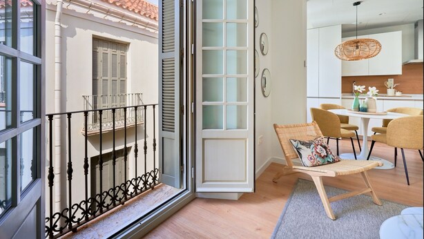 Une cuisine moderne avec un coin repas, un balcon doté d’une rambarde et une porte-fenêtre coulissante.