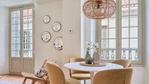 Un coin repas avec une table ronde, quatre chaises et un luminaire suspendu.