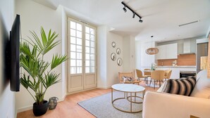 Un salon moderne avec un canapé, une table basse et une plante en pot.