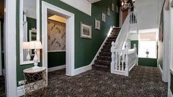 A staircase with white balustrades and a patterned carpet.