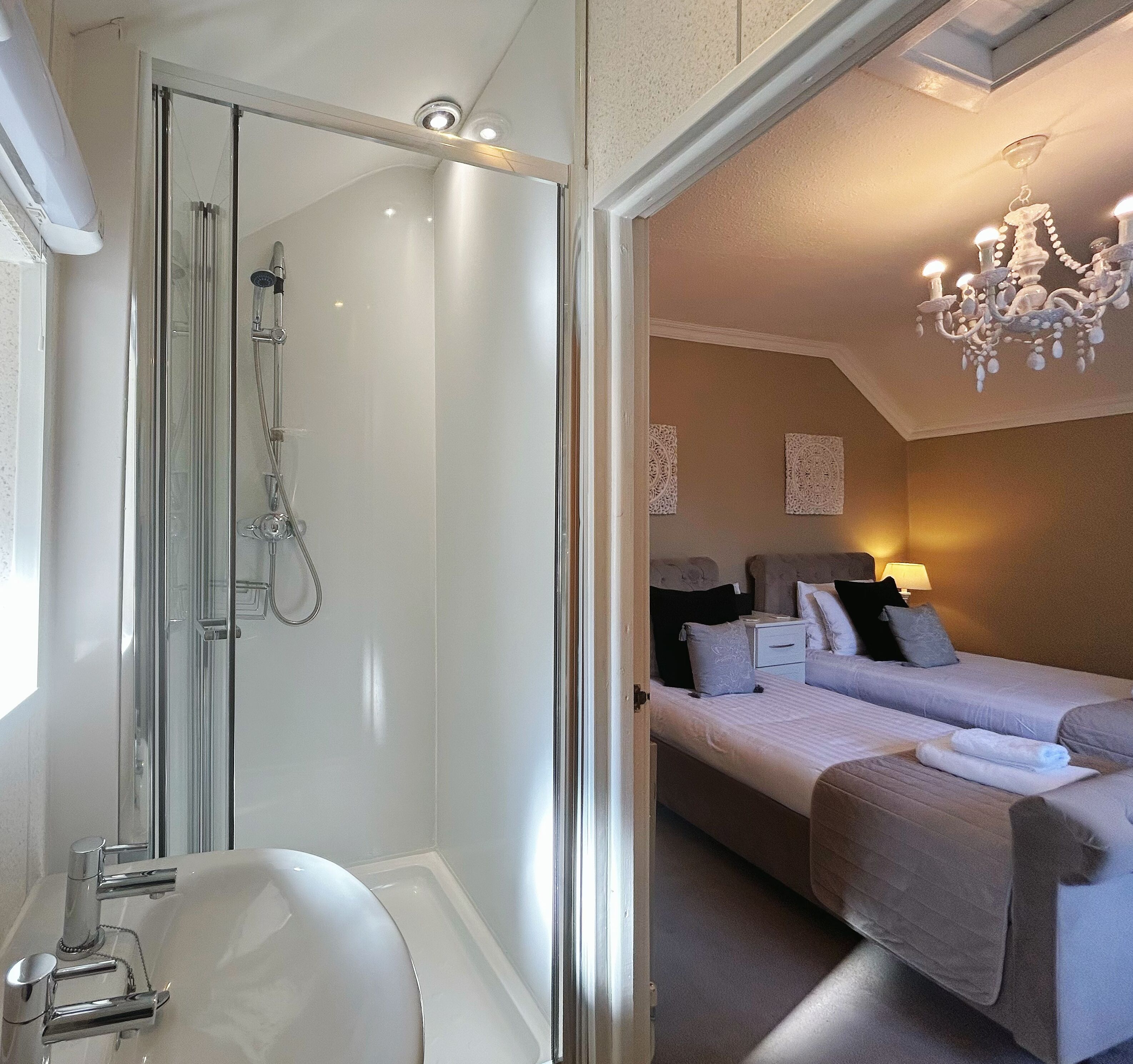 A bathroom with a glass-enclosed shower and a white sink.