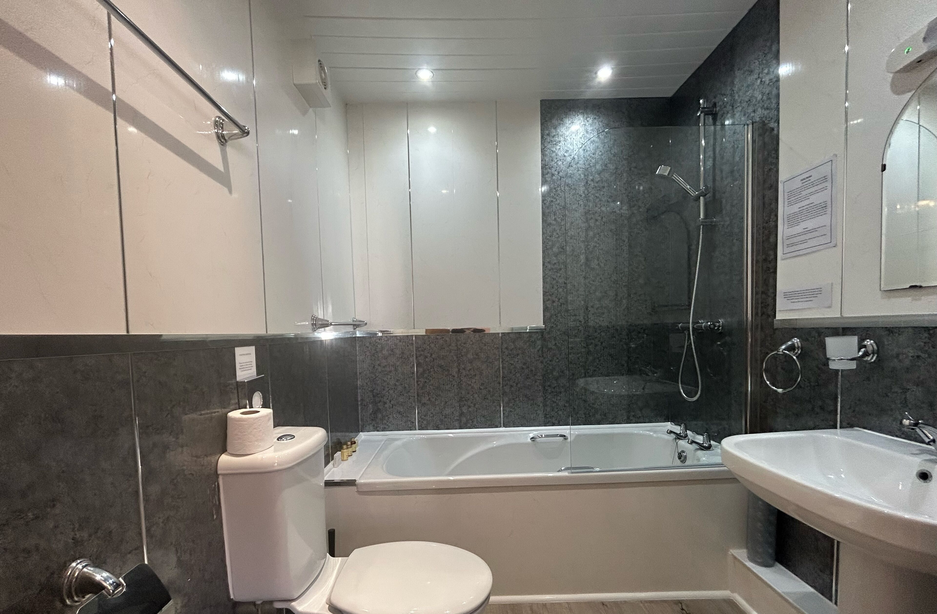 A modern bathroom with a toilet, bathtub, and sink.