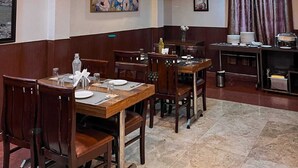 Un restaurant amb mobiliari de fusta, una làmpada penjant i obres d'art a les parets.