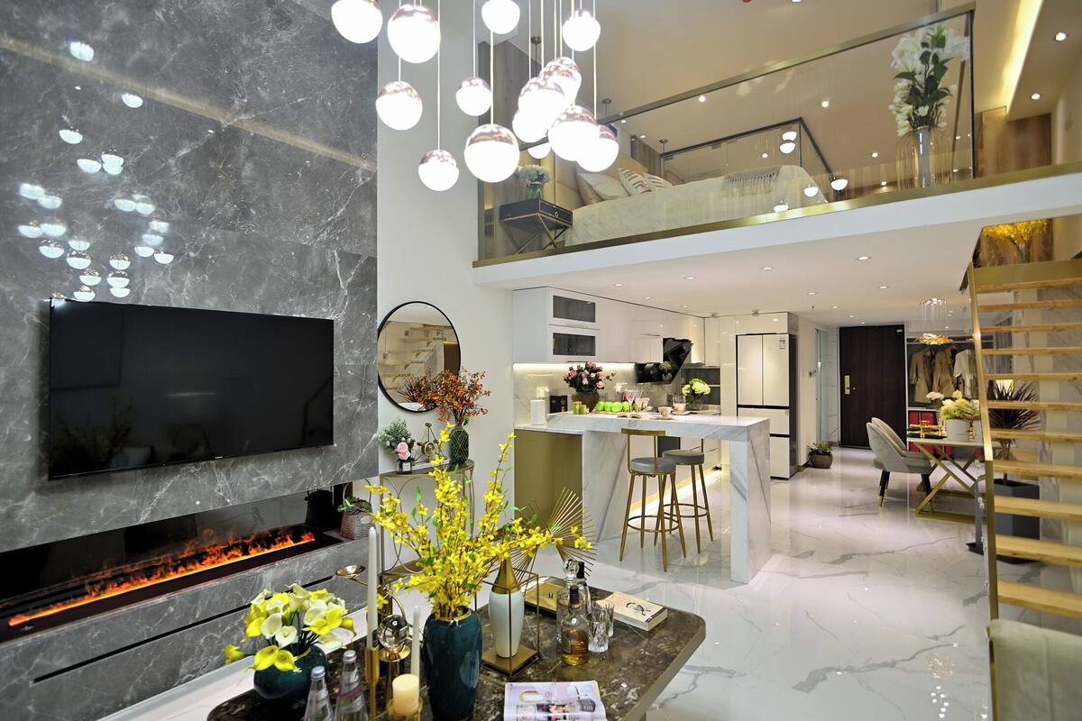 Una sala de estar moderna con televisor de pantalla plana, chimenea y comedor con barra.