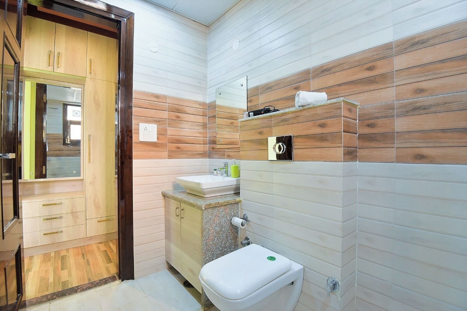 Une salle de bain avec un lambris en bois, un lavabo, des toilettes et un miroir.