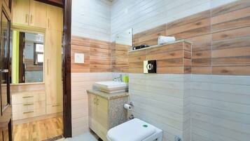 Une salle de bain avec un lambris en bois, un lavabo, des toilettes et un miroir.