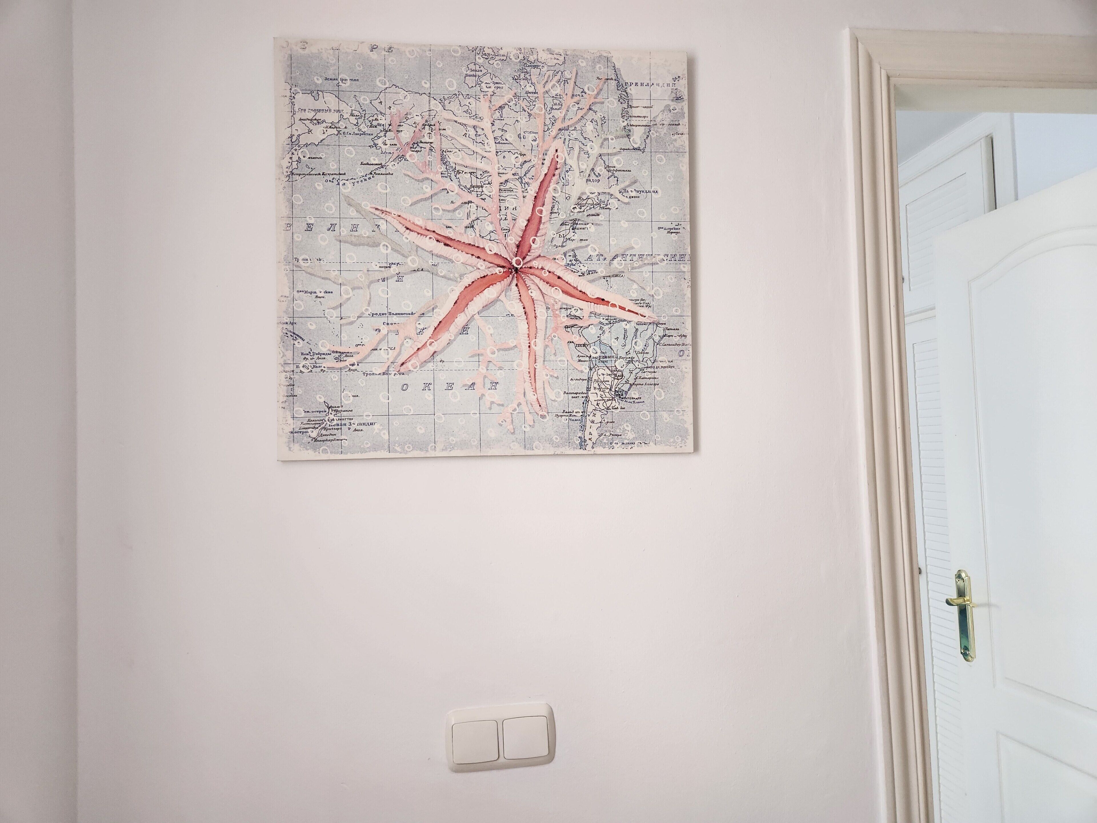 Une carte avec une étoile rouge sur un mur blanc.