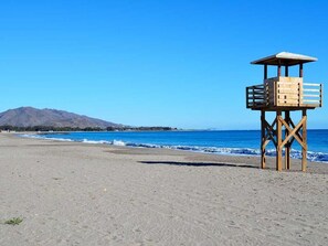 A lifeguard tower on a beach with clear skies and a mountain in the background. - Tríplex Adosado de Estancia Marítima a 2 Minutos de la Playa! (AN)