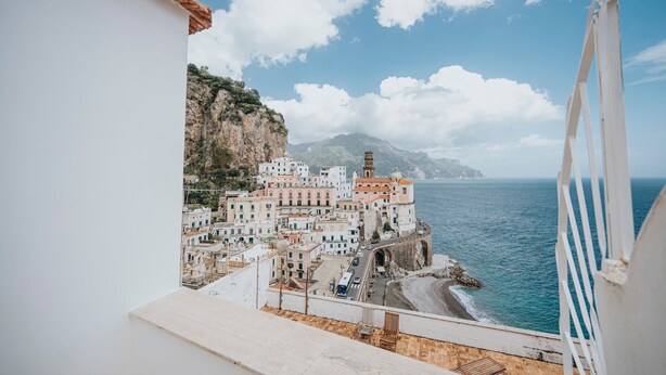 A coastal town with buildings along the sea, a prominent church, and a clear view of the ocean. - Casa Blue Torricella by Elite Villas (Atrani)