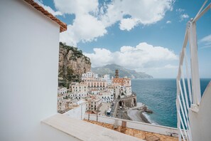 A coastal town with buildings along the sea, a prominent church, and a clear view of the ocean. - Casa Blue Torricella by Elite Villas (Atrani)
