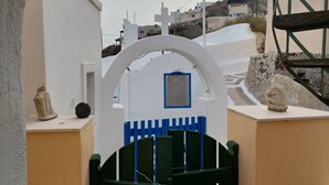 A white building with a blue window and a green gate. - Akrotiri Cosy Studio with Patio and View (Santorini)