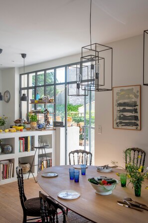 Enjoy meals with a view from this dining area featuring a table for two, bookshelf, and artwork.
