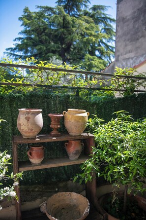Pottery and greenery adorn a serene outdoor space.