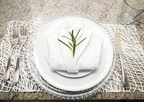 A neatly set table with a white plate, silverware, and a glass of water on a granite countertop. - Chic Haven Studio in Kingston (Kingston)