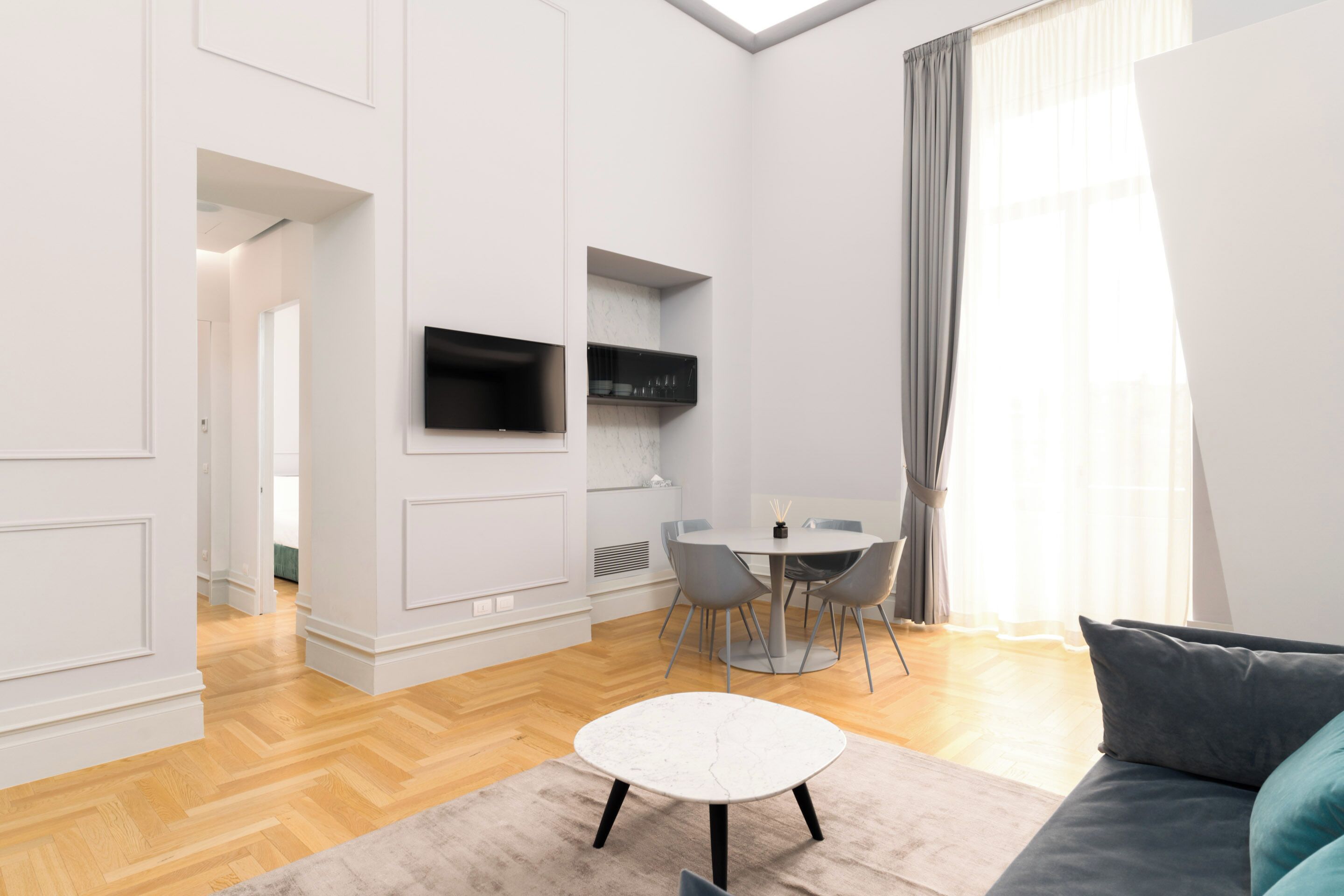 Ein modernes Wohnzimmer mit einer Couch, einem Couchtisch und einem Essbereich mit Tisch und Stühlen.