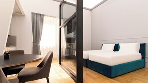 Una habitación de hotel moderna con una cama, un escritorio y una silla.
