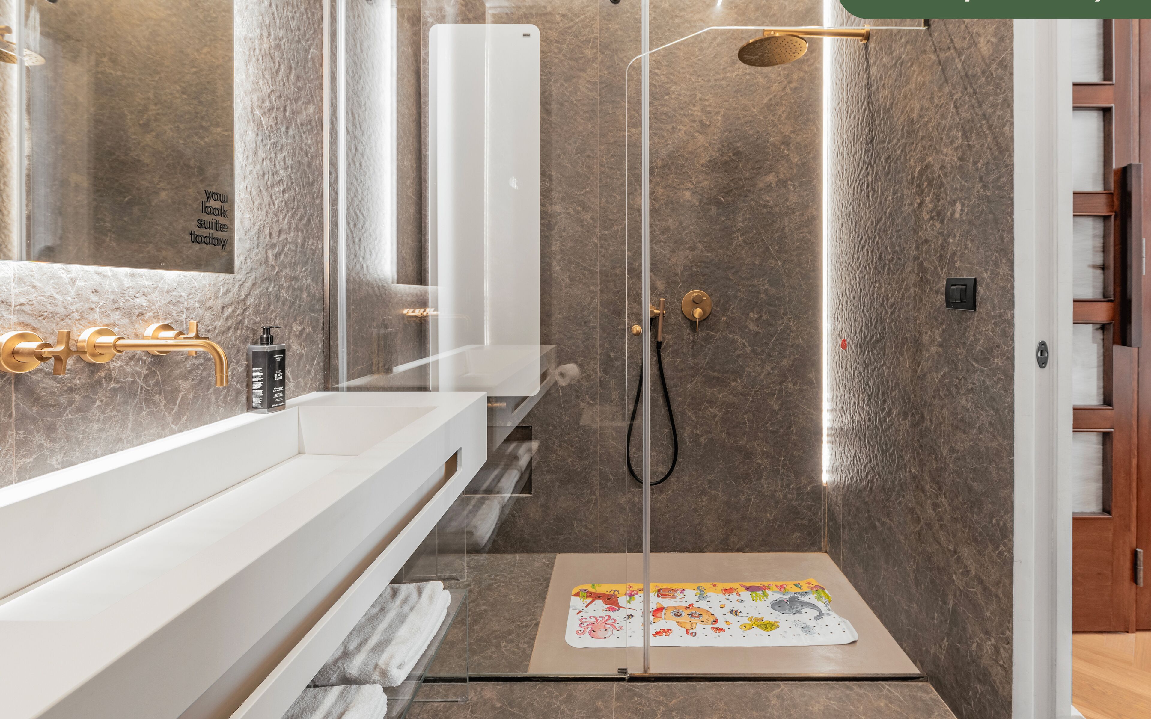 A modern bathroom with a glass shower enclosure, a white vanity, and a towel rack.