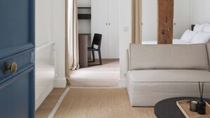 Ett modernt hotellrum med en stor säng, en soffa, ett soffbord och en garderob.
