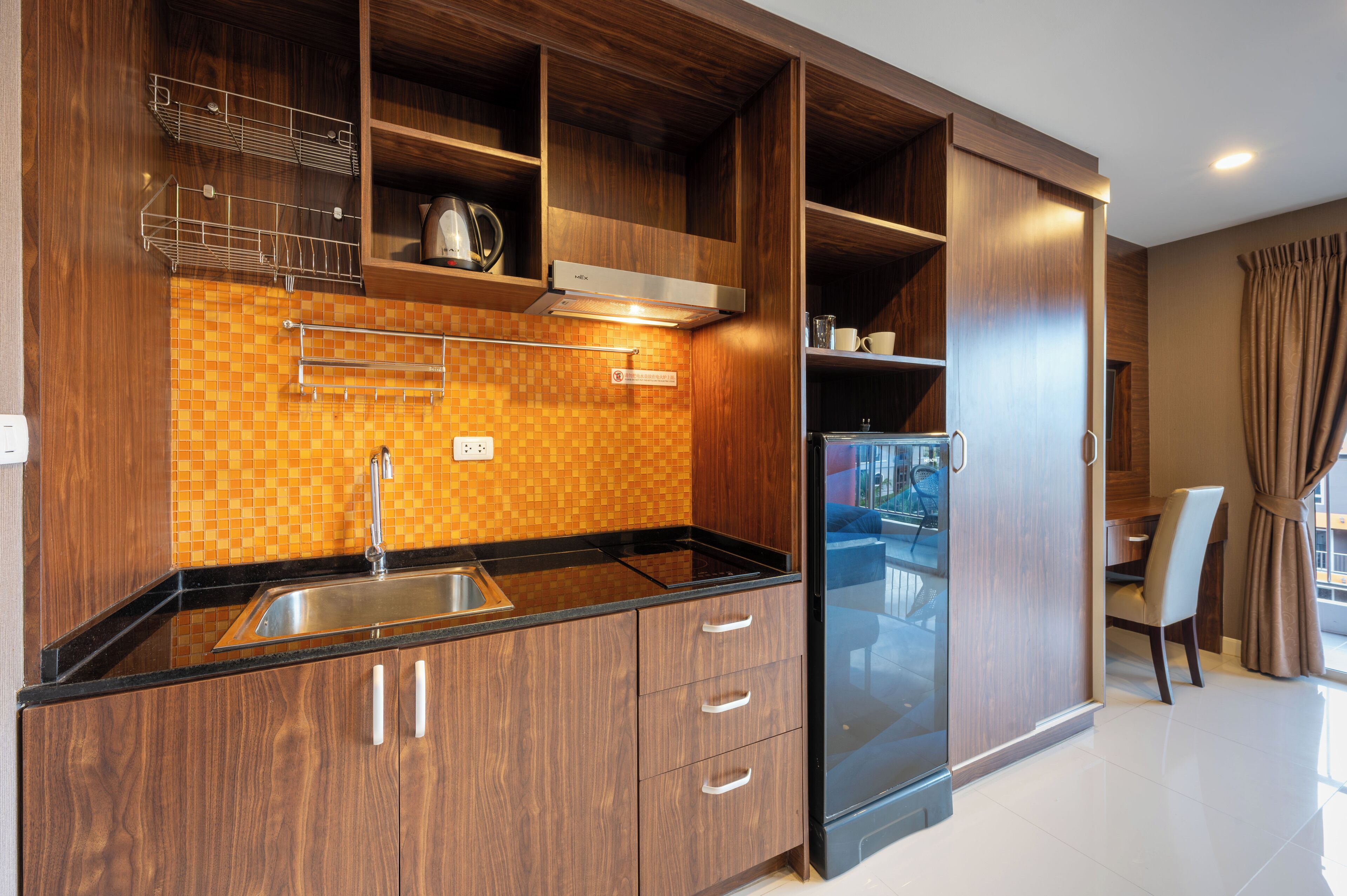 Una cocina moderna con armarios de madera, encimera negra y pileta de acero inoxidable.