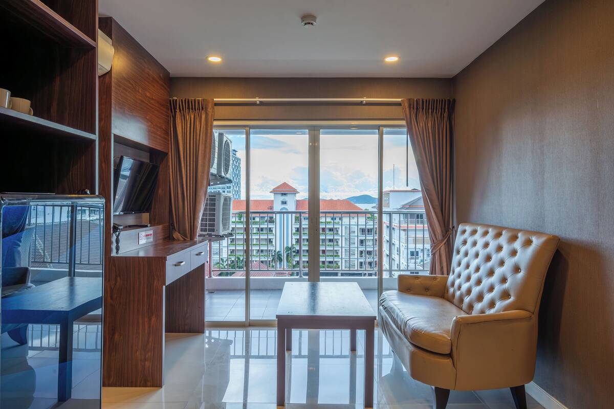 Una sala de estar moderna con un sofá, una mesa de centro y un televisor sobre un mueble de madera.