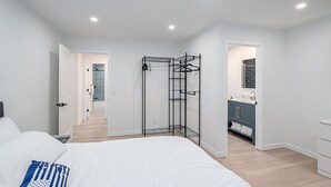 A bedroom with a bed, a walk-in closet, and a bathroom with a sink and cabinets. - 4Bdrm 3ba Pickleball, Pool Table, Nearby Marina! (Kingston)