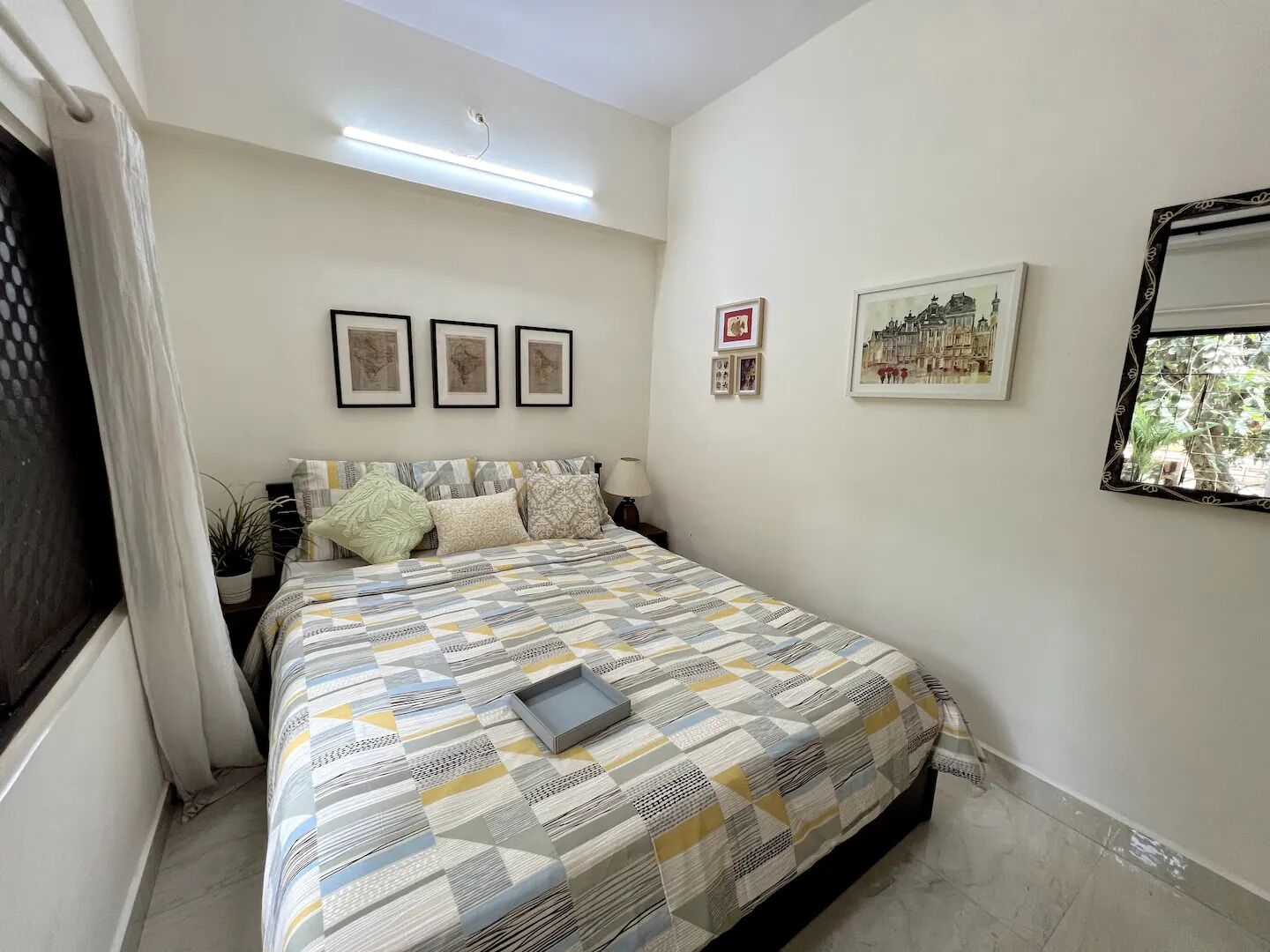 Une chambre à coucher avec un lit, une table de chevet, une lampe et une fenêtre donnant sur un beau paysage.