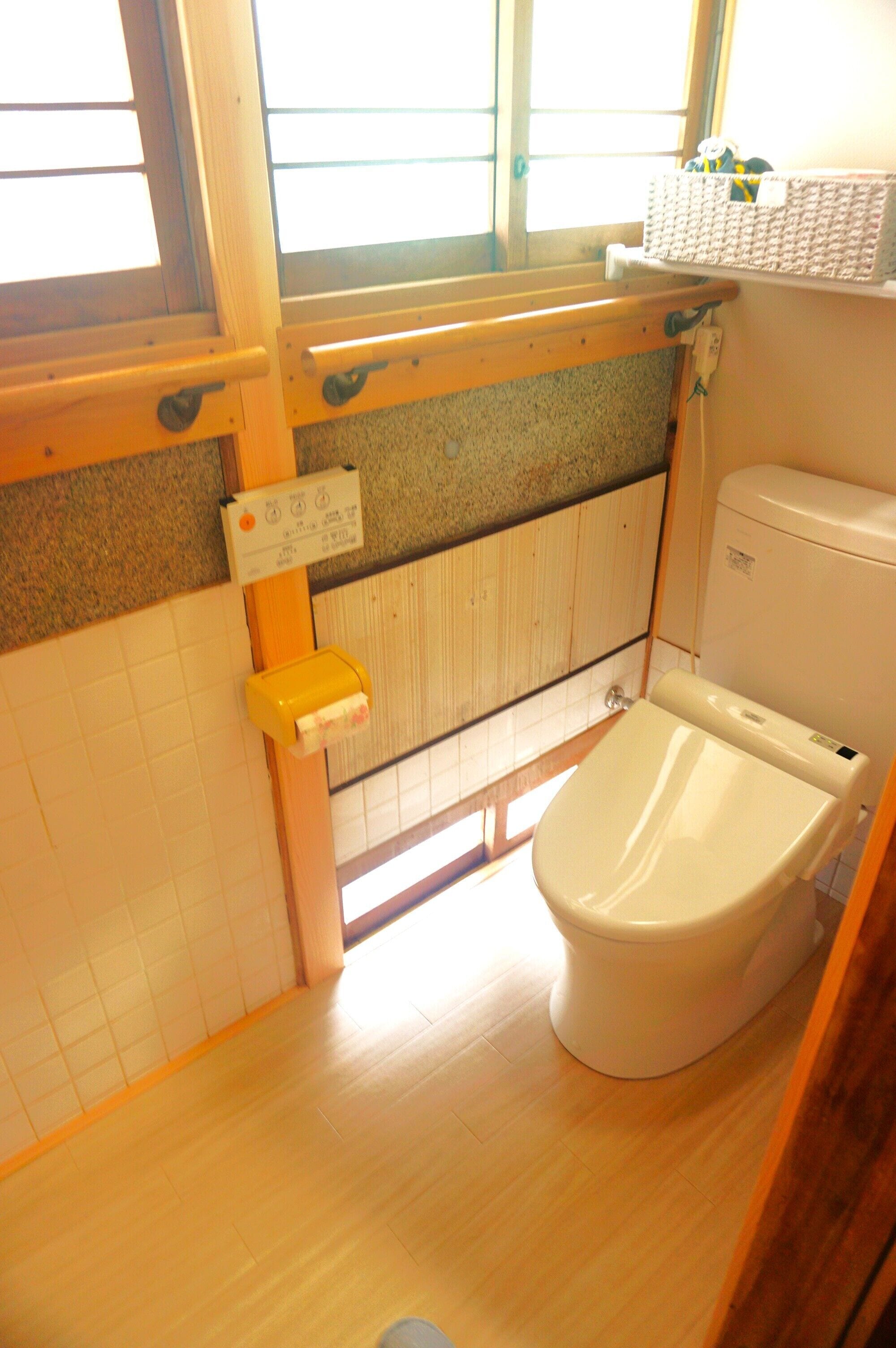 Un baño pequeño con inodoro, ventana y radiador.