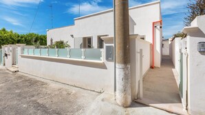 A modern building with a flat facade, a narrow entrance, and a visible utility pole. - 3877 Dalie - Monolocale by Barbarhouse (Manduria)