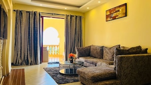 A living room with a sofa, a coffee table, and a painting on the wall. - The Penthouse Waterfronts (Mombasa)