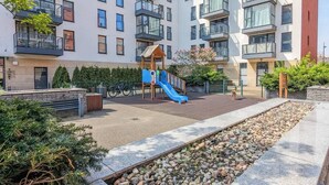 Un complesso residenziale moderno con un’area giochi, biciclette e una zona verde curata.