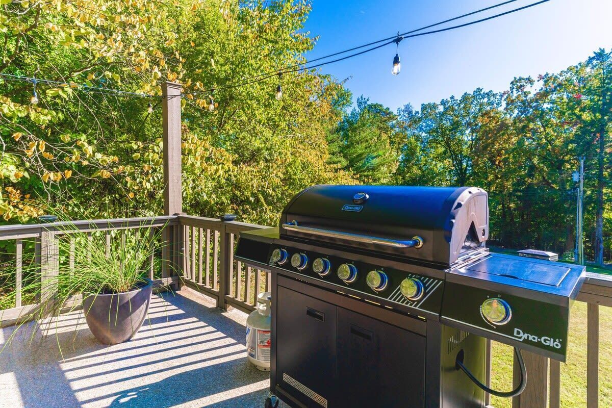 A barbecue grill with a digital display, a gas tank, and a control panel.