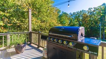 A barbecue grill with a digital display, a gas tank, and a control panel.