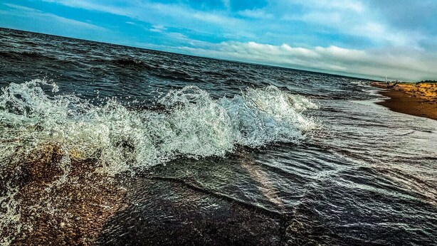 Una playa con olas rompiendo sobre la orilla.