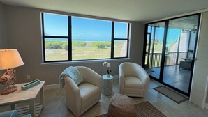 A living room with a large window offering a view of the ocean, two armchairs, a small table with a lamp, and a rug. - LOGGERHEAD CAY 501🌴Direct Gulf Front🏖️Sanibel Escape🏝️
Queen & Twin in spare room (Sanibel)