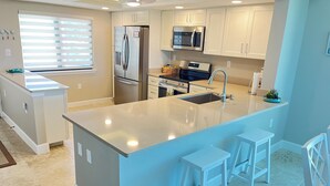 A modern kitchen with a large island, stainless steel appliances, white cabinetry, and a window with blinds. - LOGGERHEAD CAY 501🌴Direct Gulf Front🏖️Sanibel Escape🏝️
Queen & Twin in spare room (Sanibel)