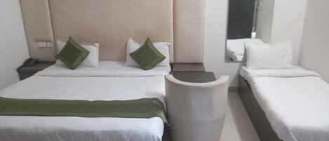 A hotel room with two beds, a large mirror, and a trash bin.