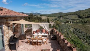 A stone building with a terrace, outdoor seating, and a view of vineyards. - Casa Luce, San Donato in Perano, Gaiole in Chianti, Siena and Chianti (Gaiole in Chianti)