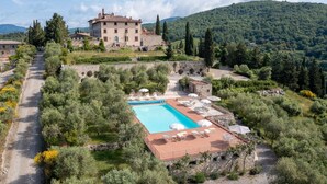 A villa with a swimming pool surrounded by lush greenery and a stone pathway leading to the entrance. - Casa Luce, San Donato in Perano, Gaiole in Chianti, Siena and Chianti (Gaiole in Chianti)