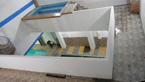 A multi-level indoor space with a pool, stairs, and a tiled floor. - Arrecifes 2 (Cartagena de Indias)