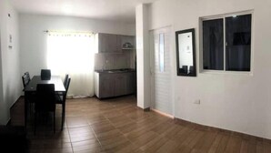 A spacious room with a dining area, kitchen, and a large window. - Arrecifes 2 (Cartagena de Indias)