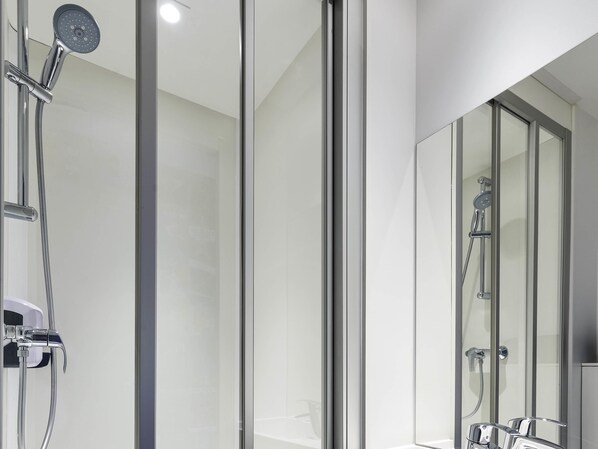 A modern bathroom with a glass shower enclosure, a handheld showerhead, and a wall-mounted faucet. - hotelF1 Amiens Est (Rénové) (Glisy)
