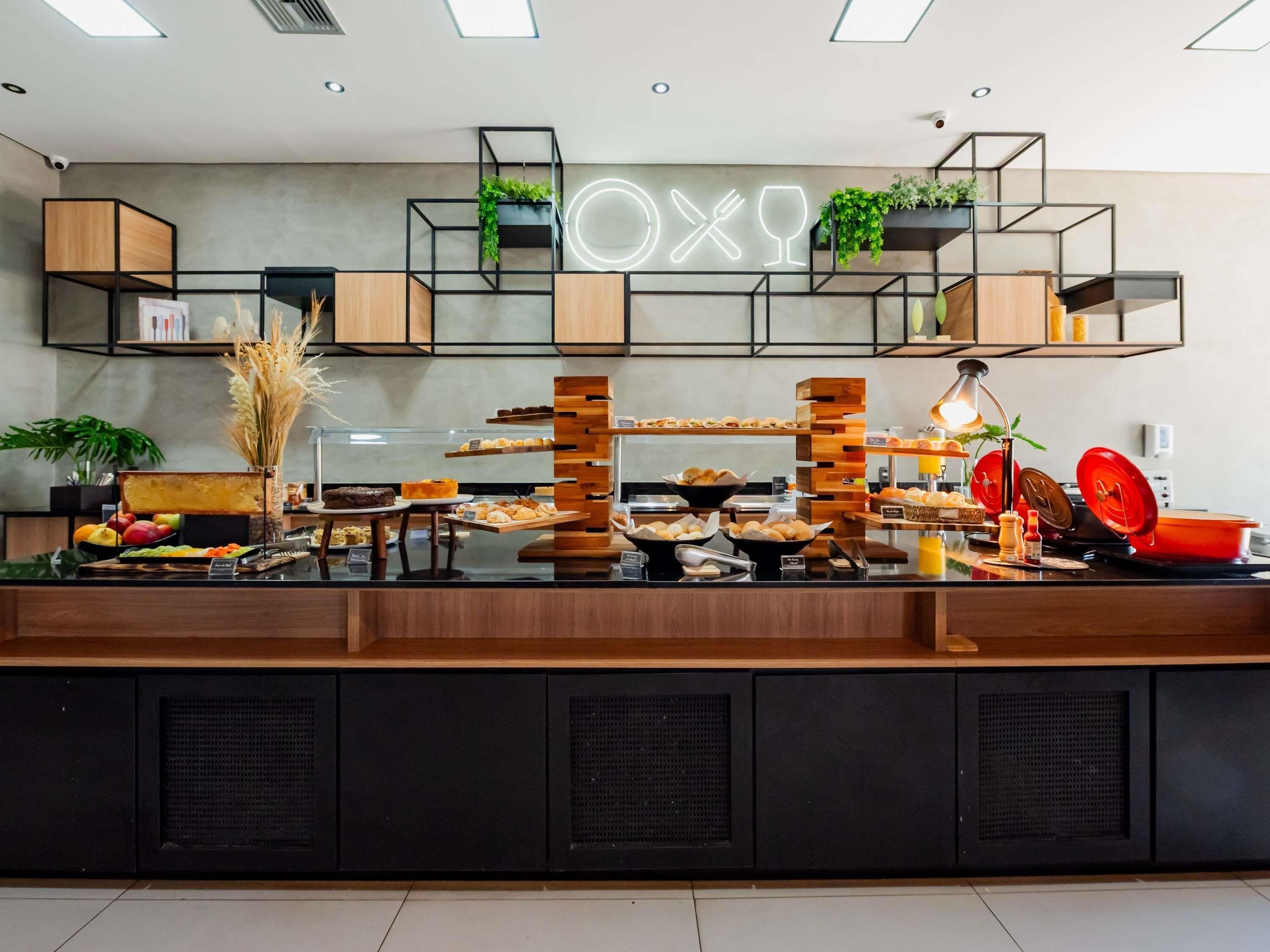 A breakfast buffet with various food items and a neon sign above.